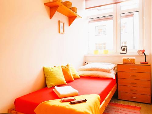 a bedroom with a red and yellow bed and a dresser at Nocleg - Gdynia Śródmieście in Gdynia