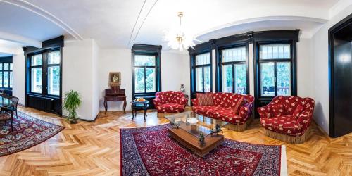a living room with red chairs and windows at Vila Olga in Jevany