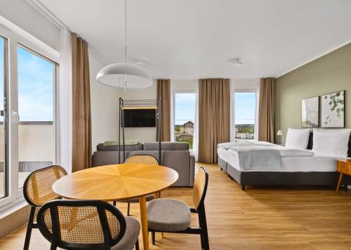 a hotel room with a bed and a table and chairs at Limehome Bochum Kortumstr in Bochum
