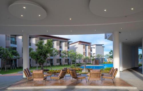 a courtyard with chairs and a table and a pool at i Tara Private in Phetchaburi
