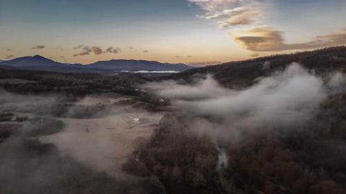 an aerial view of a foggy valley with trees at Secluded Dome Retreat near Elena & Bikes 
