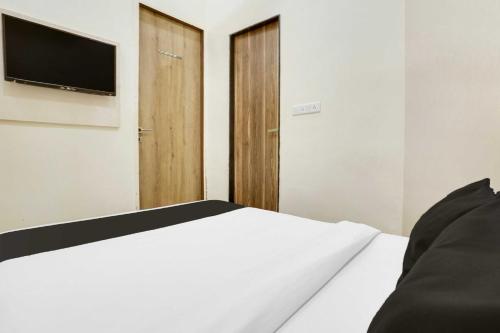a bedroom with a bed with a tv on the wall at Townhouse Ville Parle in Mumbai