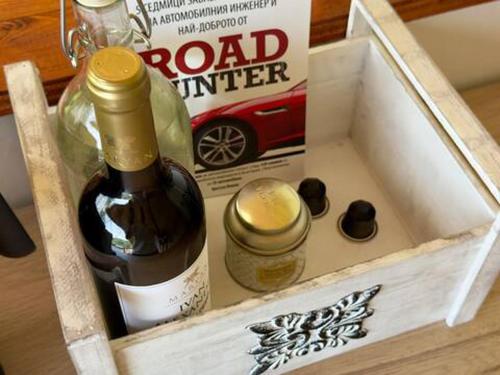 a wooden box with a bottle of wine and a magazine at Secluded Dome Retreat near Elena & Bikes 