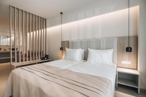 a bedroom with a large white bed with white pillows at Golden Coast Suites in Kipseli