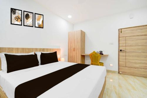 a bedroom with a large bed and a yellow chair at Collection O LB Nagar Metro Station in Hyderabad