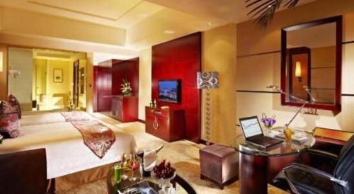 a bedroom with a bed and a desk in a room at Gaosu New Century Hotel International Anhui in Hefei