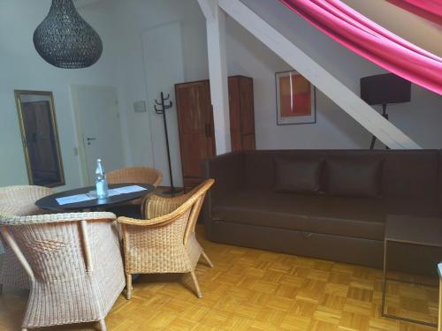 a living room with a couch and a table and chairs at WHLIVING - Apartments & Studios in Konstanz in Konstanz