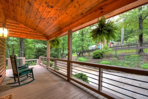 a screened porch with a chair on a wooden deck at A Little Bit of Heaven Swim in the creek soak in the hot tub and relax in comfort in Copperhill