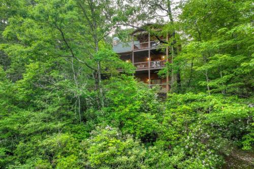 a house in the middle of a forest with trees at A Little Bit of Heaven Swim in the creek soak in the hot tub and relax in comfort in Copperhill