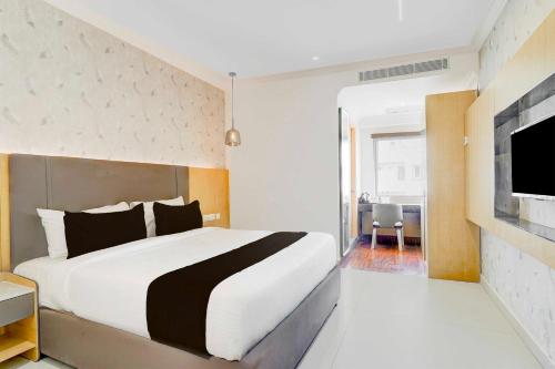 a bedroom with a large bed and a tv at Collection O AECS Layout Brookefield in Bengaluru
