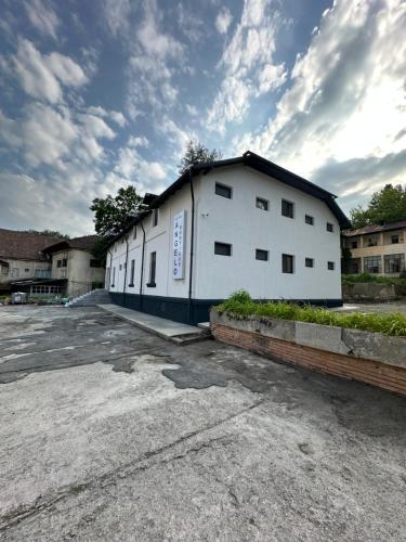 un edificio blanco en un estacionamiento en Hotel Angelo Boutique, en Prăjila