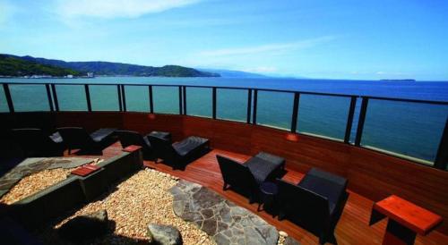 a balcony with chairs and a view of the water at Luxury Wa Hotel Kaze No Kaori in Ito