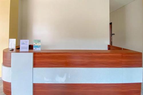 a counter with two signs on top of it at Sans Stay Syariah Asyifa Purwokerto in Purwokerto