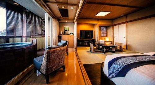 a bedroom with a bed and a tub in a room at Luxury Wa Hotel Kaze No Kaori in Ito
