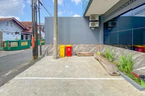 a street with two trash cans on the side of a building at Sans Stay Syariah Asyifa Purwokerto in Purwokerto
