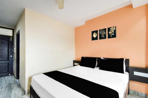 a bedroom with a bed with black and white pillows at Townhouse Secunderabad Near Railway Station Formerly Hotel Brahma in Hyderabad