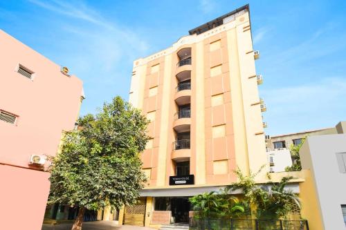 a tall building with a tree in front of it at Townhouse Secunderabad Near Railway Station Formerly Hotel Brahma in Hyderabad