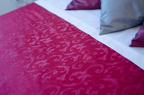 a red and white blanket on a bed with pillows at Agriturismo Tenuta Umberto I in Ripacorbaria