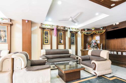a living room filled with furniture and a flat screen tv at Townhouse Secunderabad Near Railway Station Formerly Hotel Brahma in Hyderabad