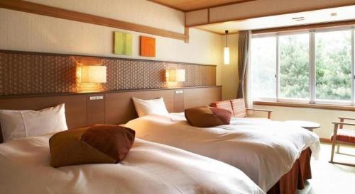 a hotel room with two beds in a room at Kyoto Keburikawa Hotel in Kameoka