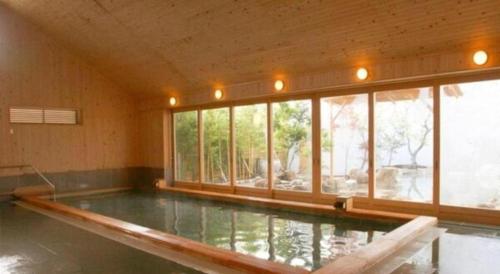 a swimming pool in a room with windows at Hirata Maple Hotel in Izumo
