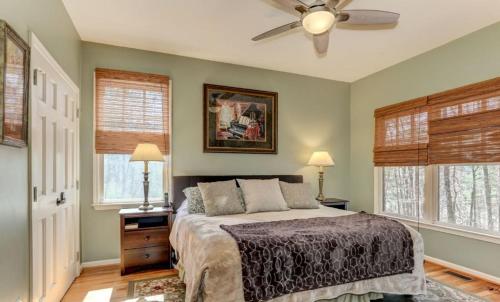 a bedroom with a bed and a ceiling fan at Mountain Acres Retreat - Relax by the wood fireplace and more in Jasper