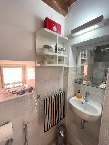 a small bathroom with a sink and a mirror at Romantic House in Trevignano Romano