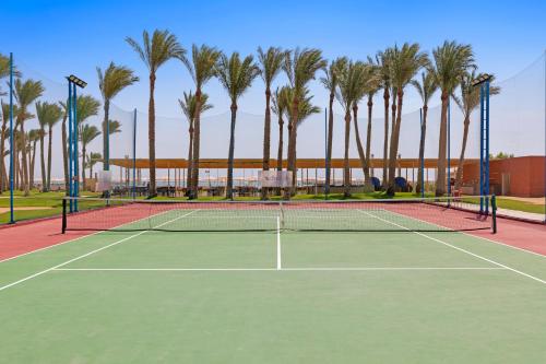 a tennis court with palm trees in the background at Pickalbatros Laguna Club Resort Sharm El Sheikh in Sharm El Sheikh