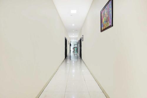 a long hallway with white walls and a painting on the wall at Townhouse Dabagardens Near Railway Station in Visakhapatnam