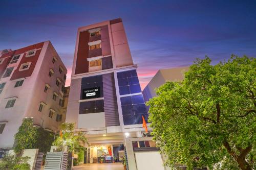 a building with two tall buildings and a tree at Collection O Dwarka Nagar Ramatalkies in Visakhapatnam