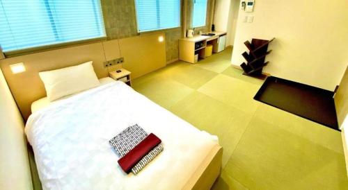 a bedroom with a bed with a red book on it at NAMBA EBISU HOTEL in Osaka