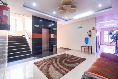 a living room with a couch and a staircase at Collection O CMR Mall Gajuwaka in Visakhapatnam