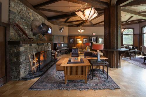 a living room with a fireplace and a stone wall at Deer Lodge in Lake Louise