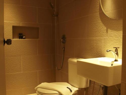 a bathroom with a toilet and a sink at The Shop Hotel in Kuala Kangsar