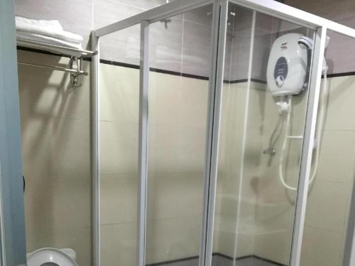 a shower stall in a bathroom with a toilet at Loong Fatt Hotel in Sungkai