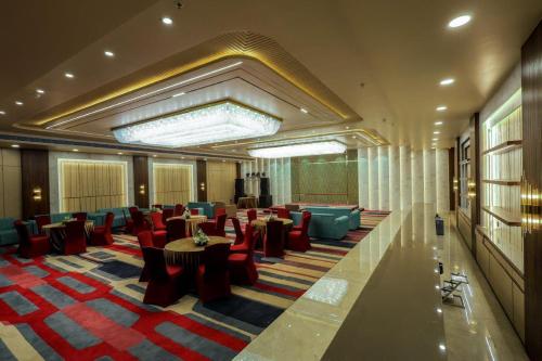 a lobby with chairs and tables in a hotel at Hotel The Golden Tree in Prayagraj