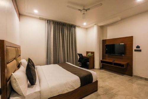 a hotel room with a bed and a flat screen tv at Hotel The Golden Tree in Prayagraj