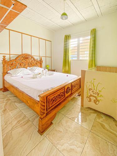 a bedroom with a large wooden bed in a room at Villa Eruptif - Proche Volcan - 15pers - By Sister Home in Le Tampon