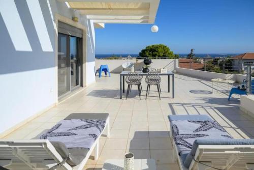a patio with a table and chairs on a balcony at Alba - Open Plan Apartment in Artemida