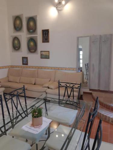 a living room with a couch and a table and chairs at Sweet Home & Apartments in Fontane Bianche