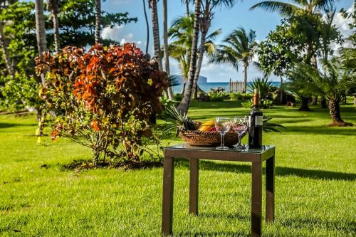 a table with wine glasses and a basket of fruit at Villa Ixora - Ocean Front in Las Galeras