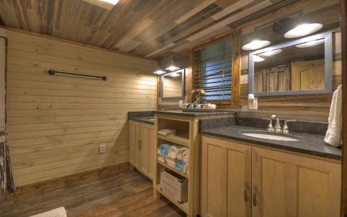 ein Badezimmer mit Waschbecken und Spiegel in der Unterkunft Knotty Creek Retreat - Creek Access, Outdoor Firepit + Hot Tub with Creek Views! in Morganton