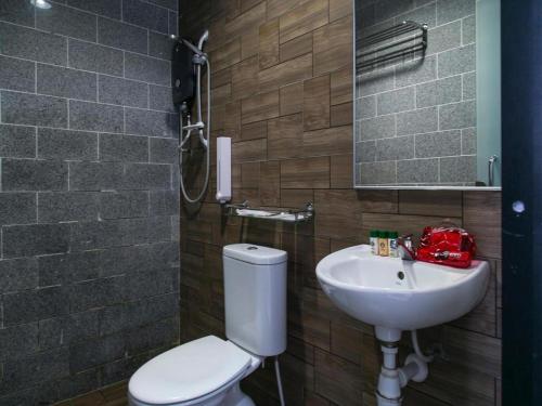 a bathroom with a toilet and a sink at OYO 223 D' Metro Hotel in Kampong Melayu Kebun Bunga
