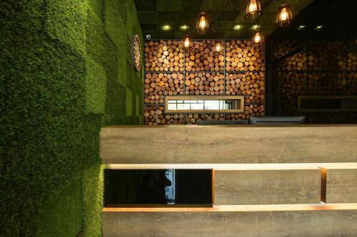 a bench in a restaurant with a green wall at Laman Green The Boutique Hotel in Kampong Melayu Kebun Bunga