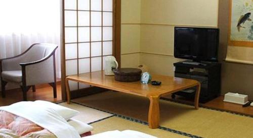 a living room with a coffee table and a television at Hotel Abest Aomori in Aomori