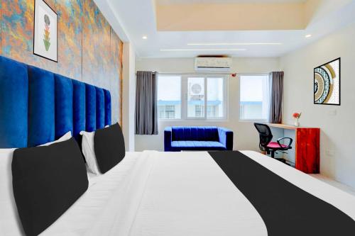 una camera d'albergo con un letto grande e una sedia di Collection O Mysore Central a Mysore
