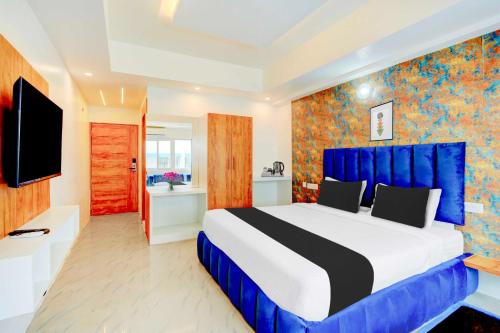 una camera da letto con un letto grande e una TV di Collection O Mysore Central a Mysore
