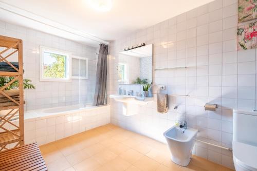 a bathroom with a toilet and a tub and a sink at Villa Marilen in Santa Margalida