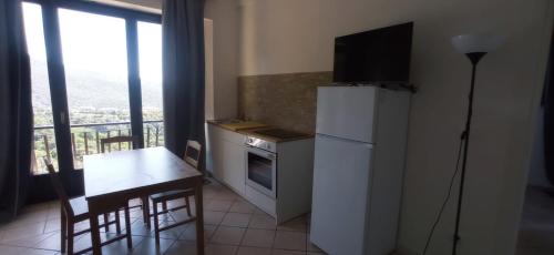 a kitchen with a table and a refrigerator and a table and chairs at ROMANTICA TOSCANA in Scarlino