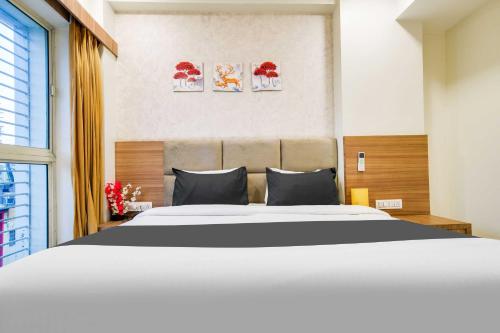 a bedroom with a large bed and two paintings on the wall at Townhouse Indore Junction in Indore